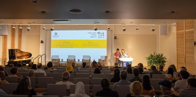 MCs and audience in the auditorium of the Mandel headquarters